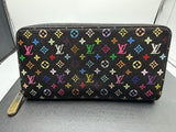 Black wallet with colorful monogram pattern on a gray surface