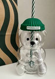 Clear glass bear with Starbucks logo and green cap on a white surface.