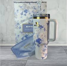 Floral-patterned tumbler with matching pouch on a wooden surface