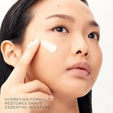 Woman applying cream to her face with text about a hydrating formula.