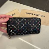 Louis Vuitton wallet with monogram pattern held by a hand on a light background