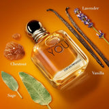 Perfume bottle labeled 'Stronger with You' by Emporio Armani on an orange background with floral and leaf elements.