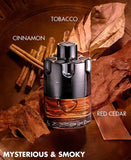 Perfume bottle with cinnamon sticks, tobacco leaves, and red cedar on a brown background