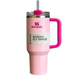 Pink Stanley tumbler with a handle on a white background