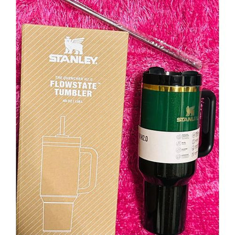 Stanley travel mug with packaging on a pink textured background
