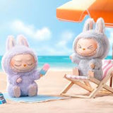 Two plush toys on a beach with an umbrella and ocean view